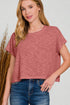 Woman wearing a pink top and blue jeans against a plain background
