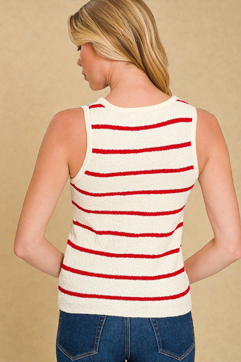 Woman wearing a white tank top with red stripes and blue jeans on a beige background