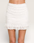 White ruffled skirt worn by a person on a plain background