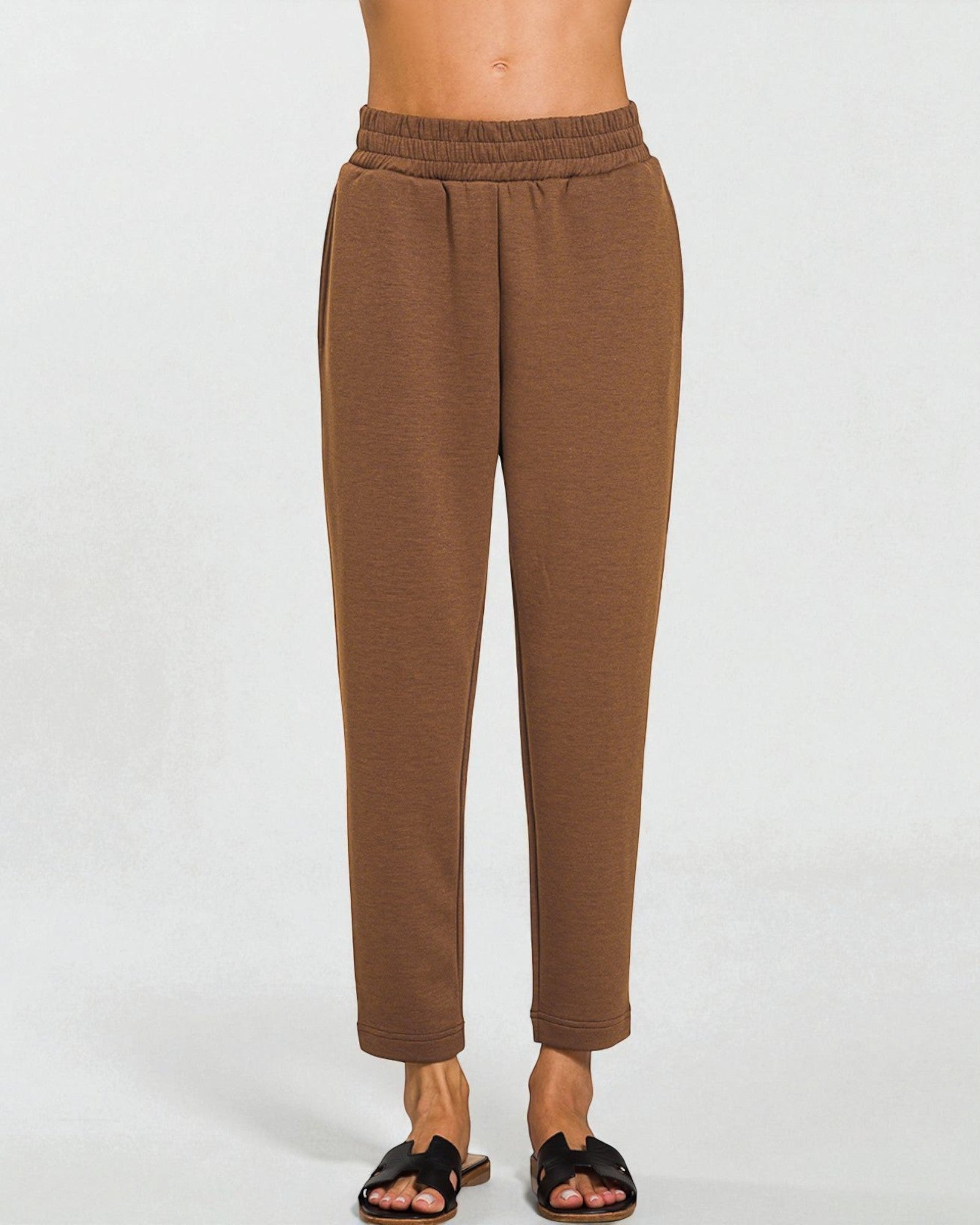 Brown pants worn by a person on a white background