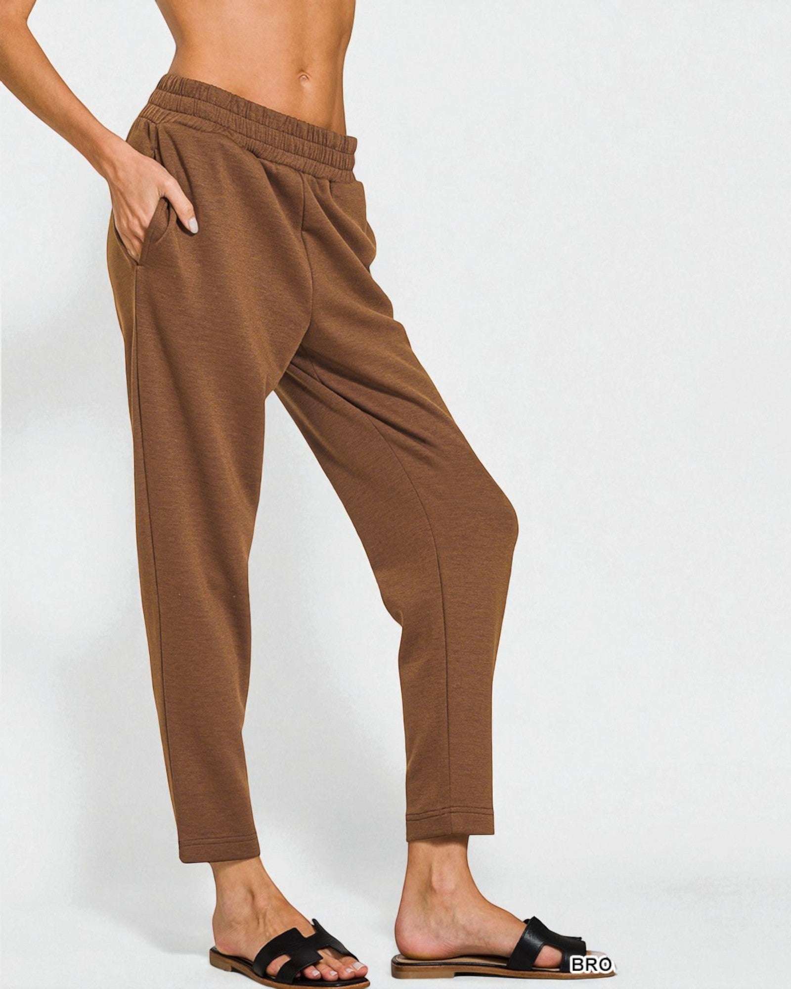 Brown pants worn by a person on a white background