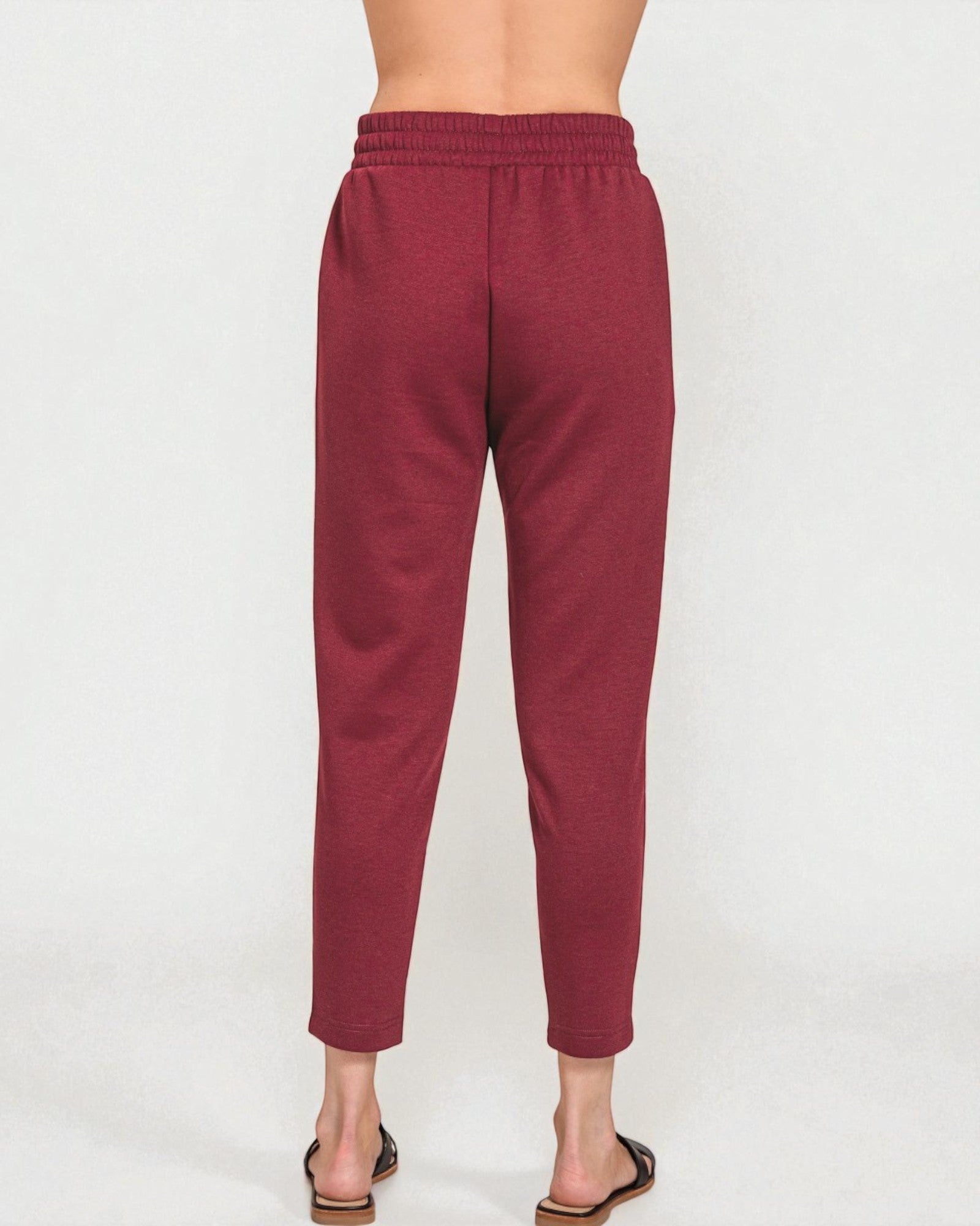 Maroon pants worn by a person on a white background