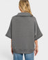 Person wearing a gray poncho over a white background