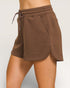Brown shorts with a drawstring on a plain background