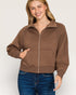 Woman wearing a brown zip-up jacket on a white background