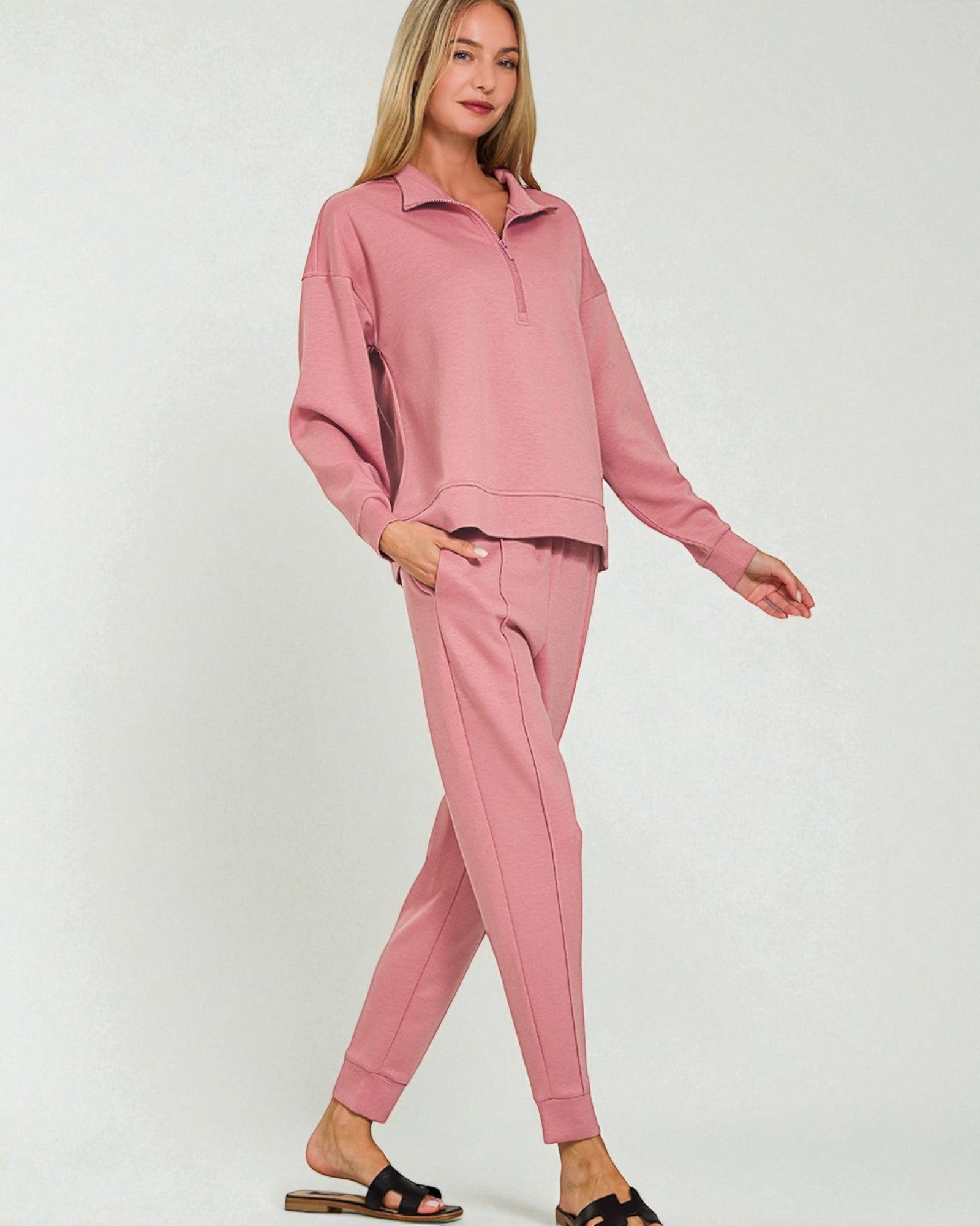 Woman wearing a pink tracksuit on a white background