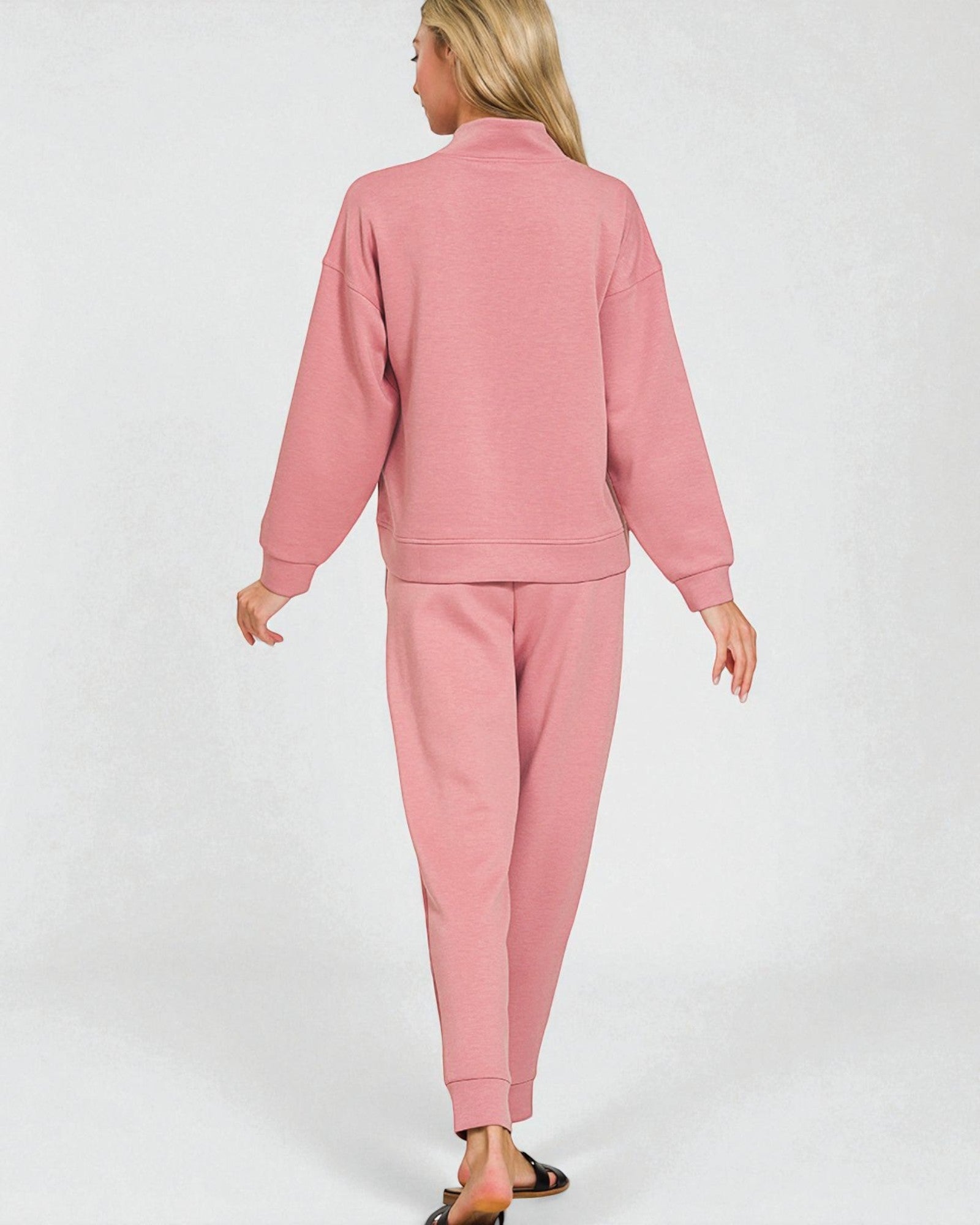 Person wearing a pink tracksuit on a white background