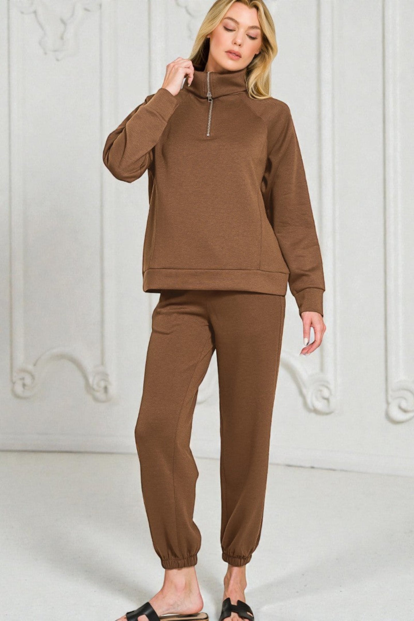 Woman wearing a brown tracksuit against a white background