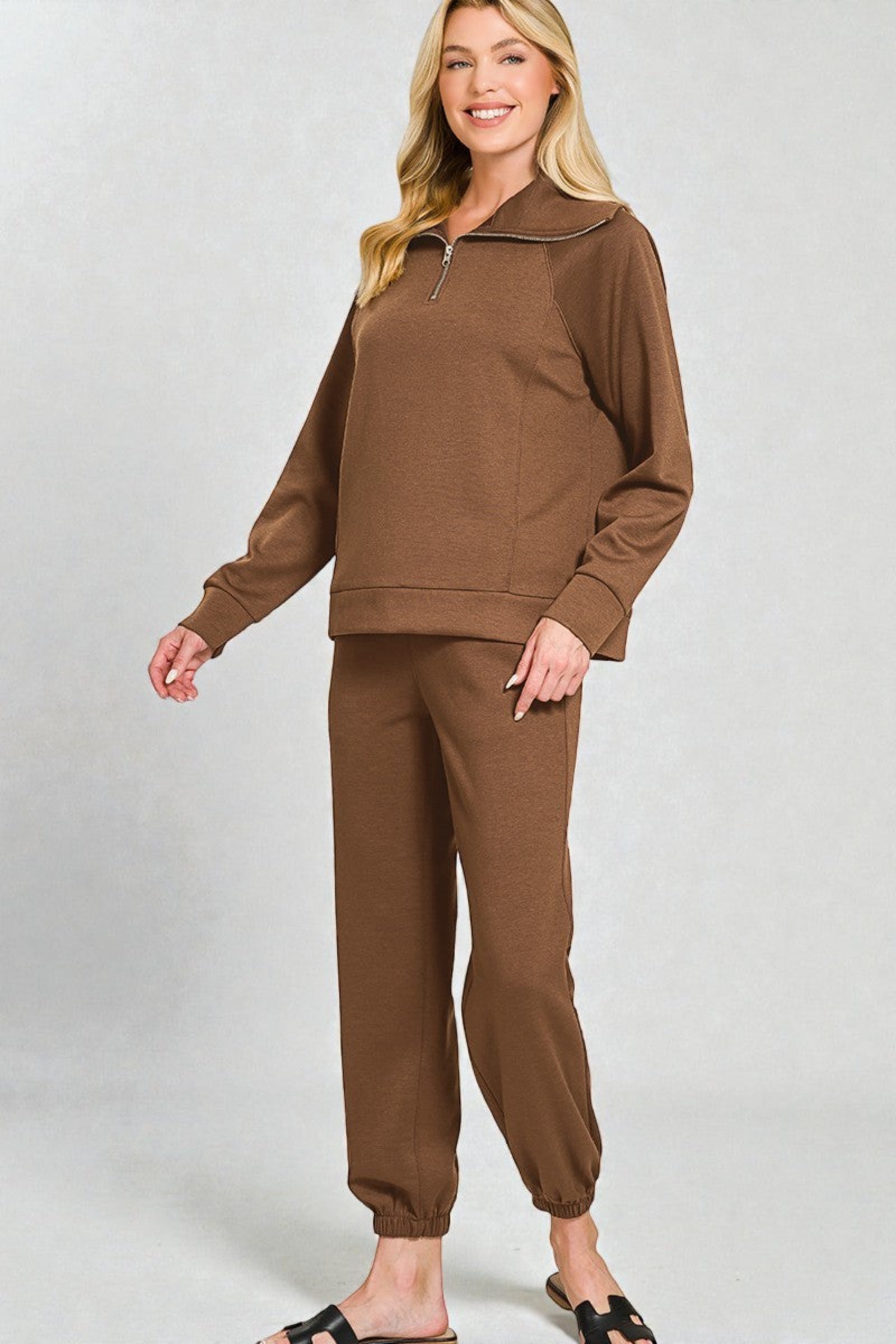 Woman wearing a brown tracksuit on a white background