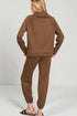 Woman wearing a brown tracksuit against a plain background