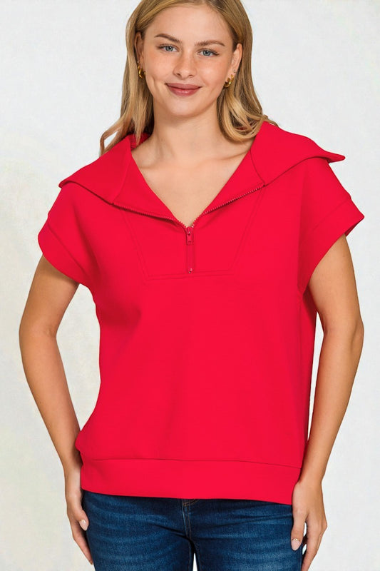Woman wearing a red short-sleeve top with a hood against a white background