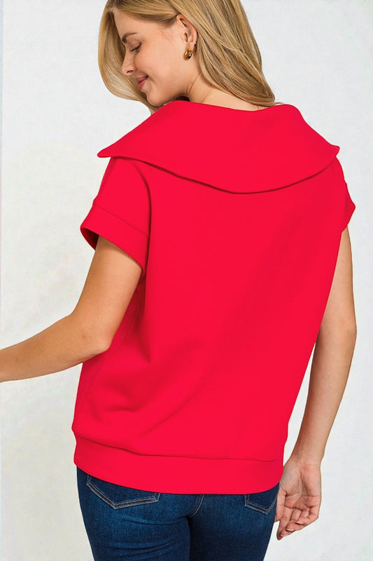 Woman wearing a red sleeveless top with a collar against a white background