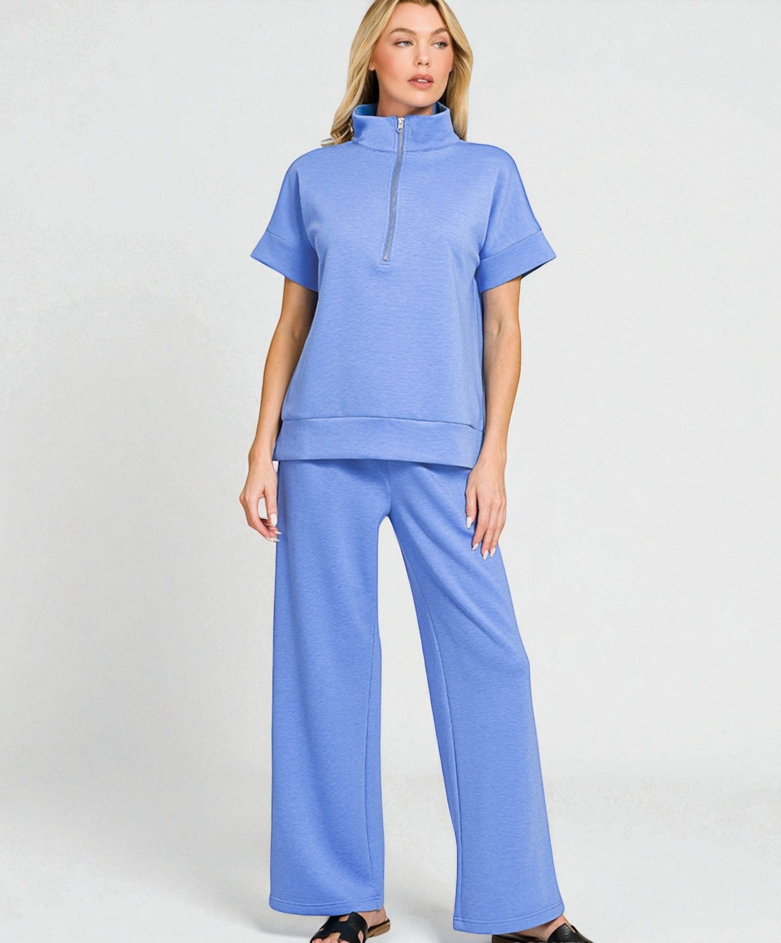 Woman wearing a blue outfit with a matching top and pants on a white background