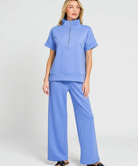 Woman wearing a blue outfit with a matching top and pants on a white background