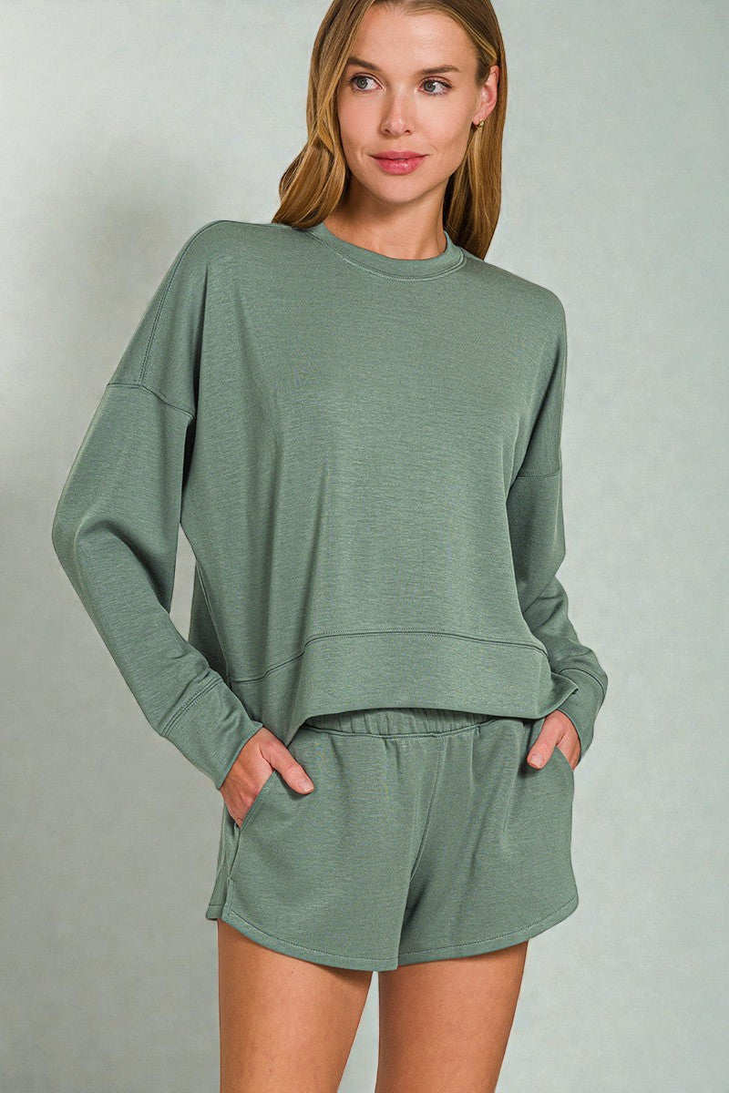 Woman wearing a green lounge set against a plain background