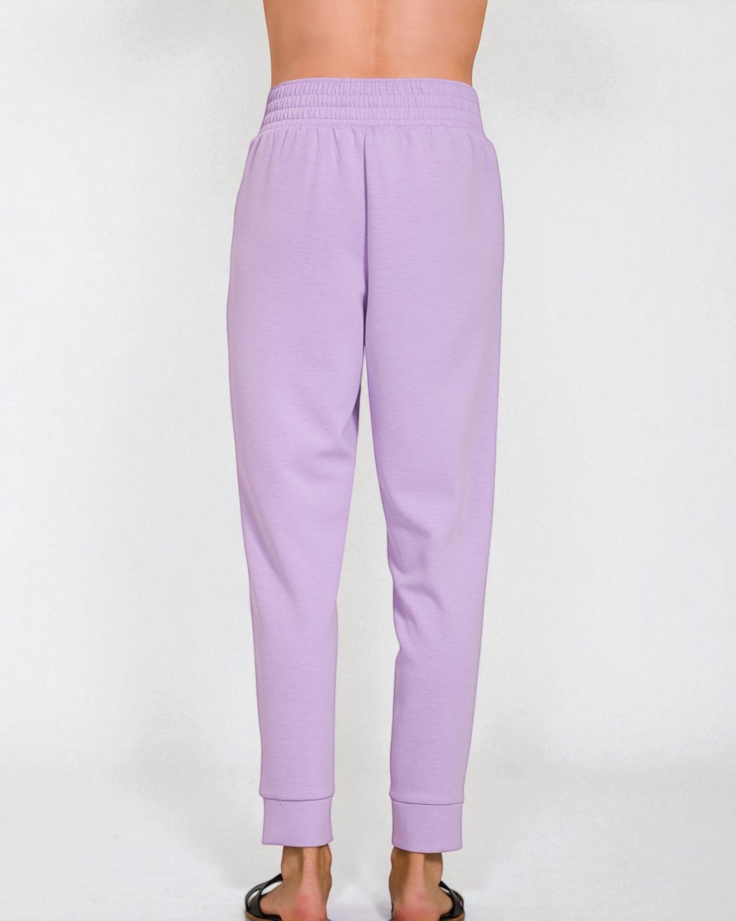 Lavender sweatpants worn by a person on a white background