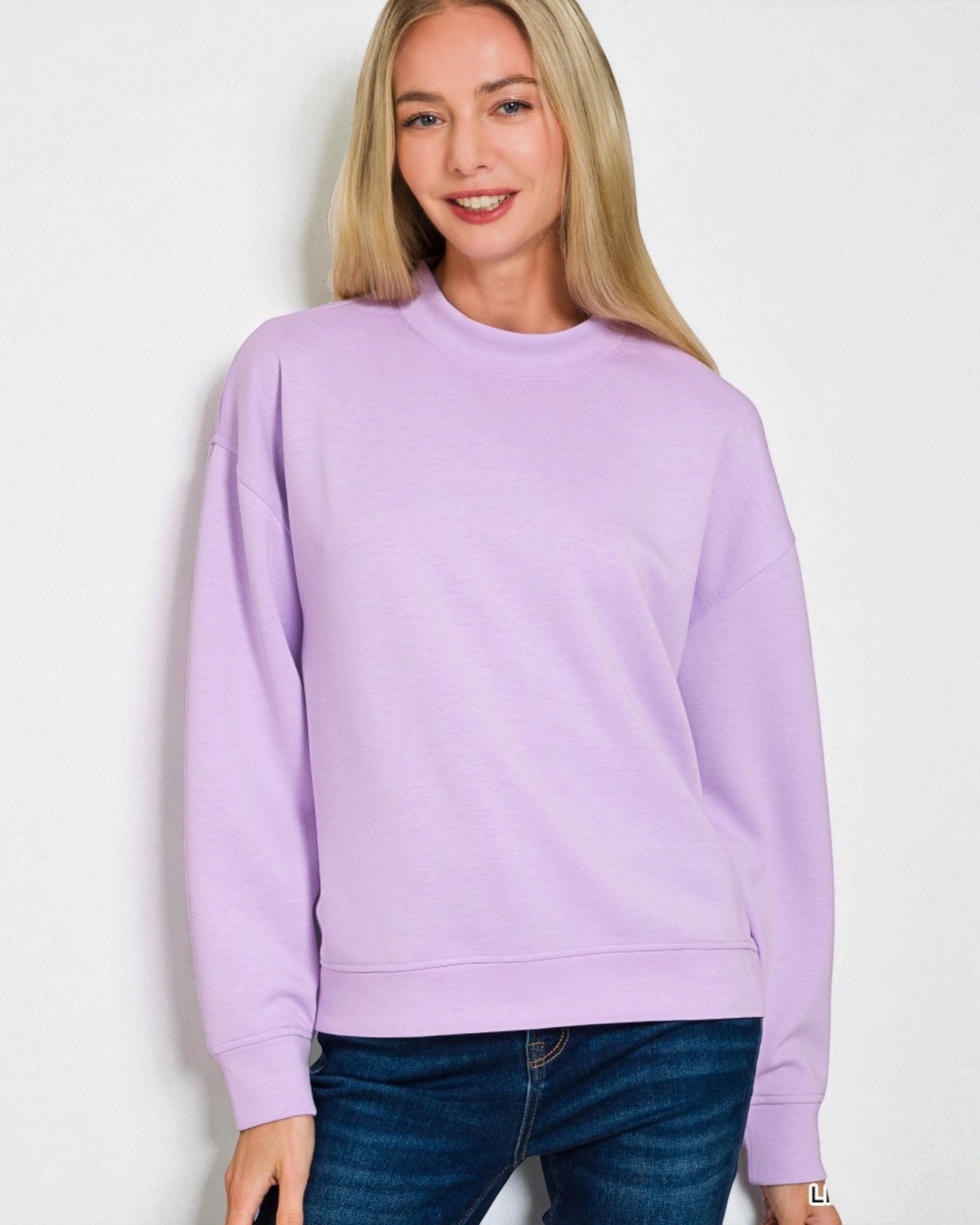 Woman wearing a light purple sweatshirt against a white background