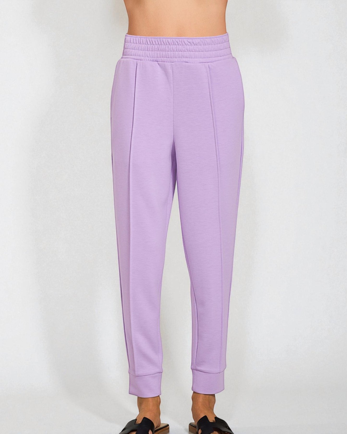 Lavender sweatpants worn by a person on a white background