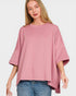 Woman wearing a pink oversized top and blue jeans on a white background