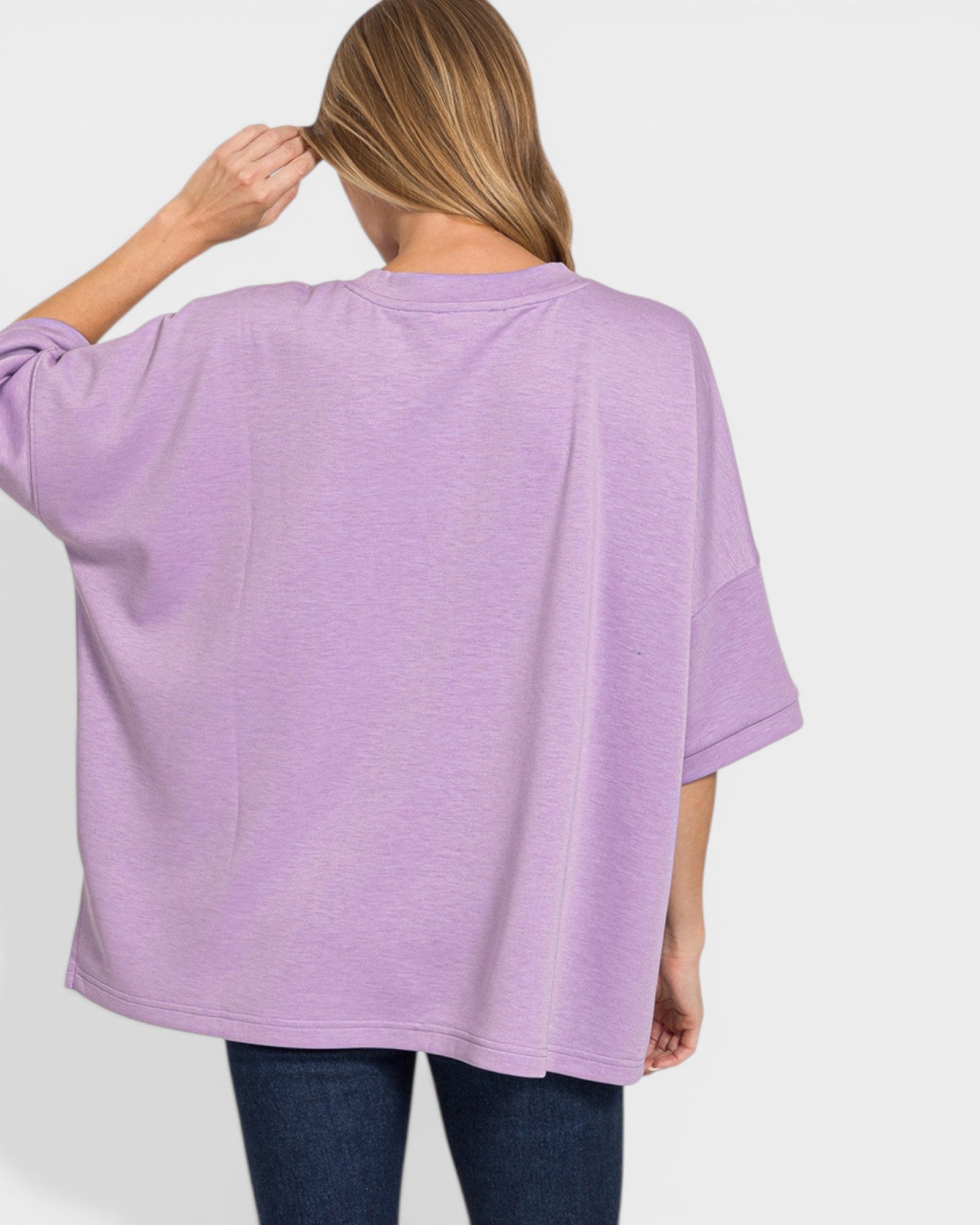 Person wearing a purple oversized shirt on a white background
