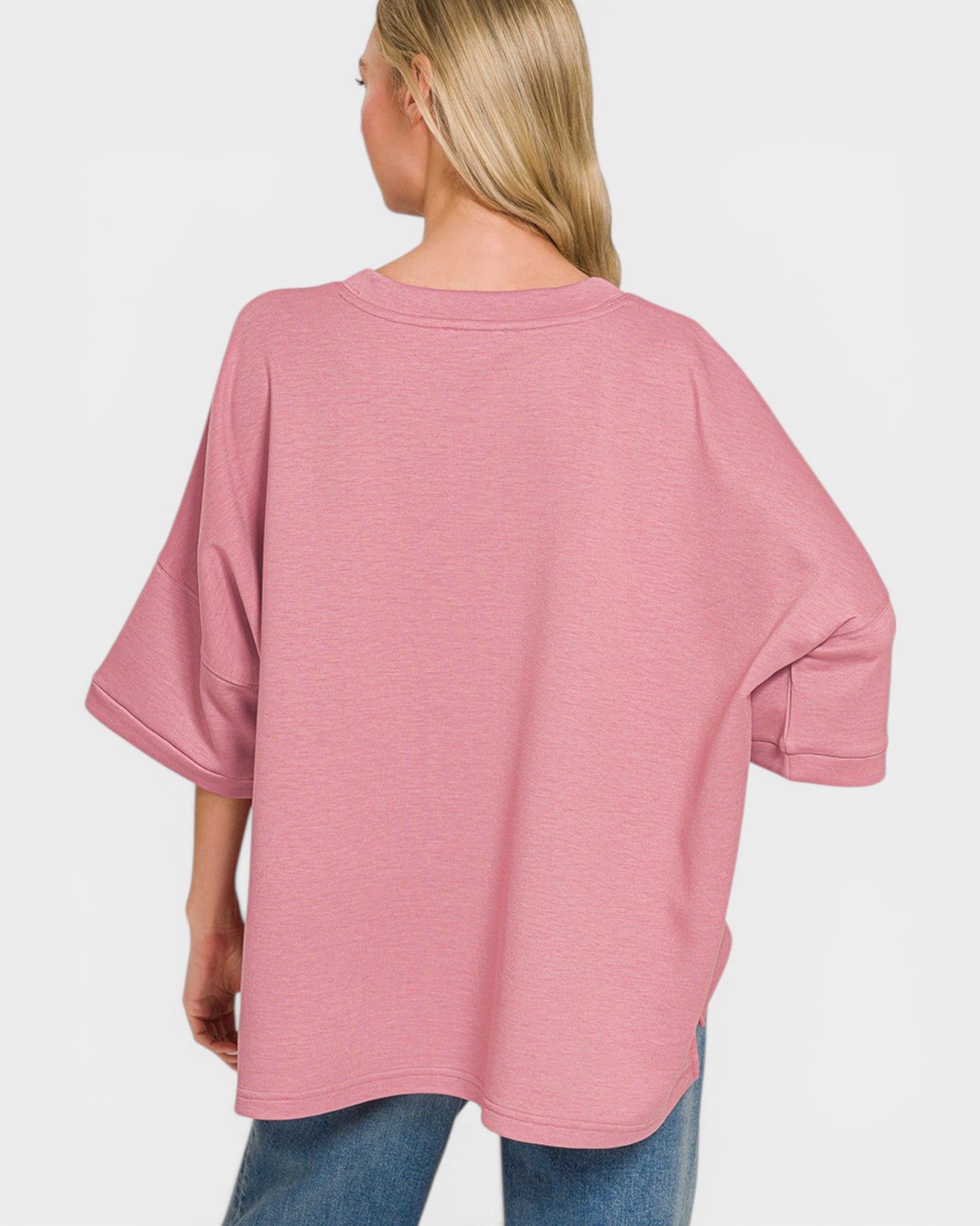 Person wearing a pink oversized sweater on a white background