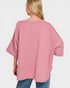 Person wearing a pink oversized sweater on a white background