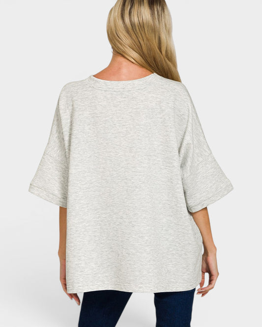 Woman wearing a light gray oversized shirt on a white background