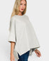 Woman wearing a light gray poncho over a white background