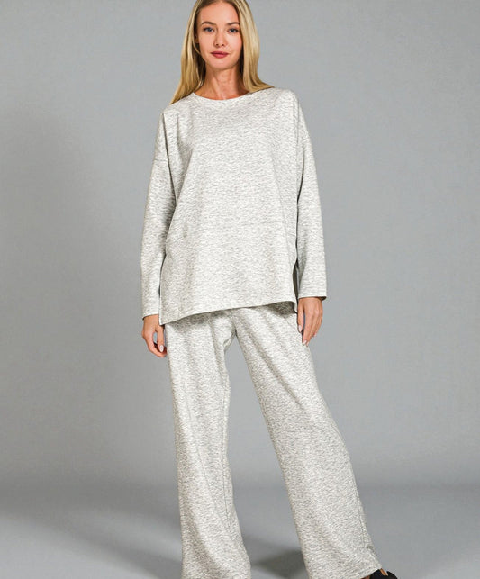 Woman wearing a light gray outfit on a plain background