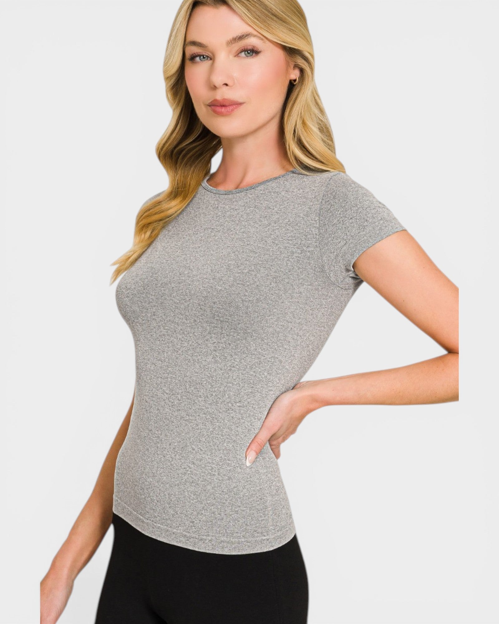 Woman wearing a gray short-sleeve top against a plain background