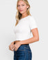 Woman wearing a white t-shirt and blue jeans on a plain background