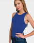 Woman wearing a blue sleeveless top against a plain background