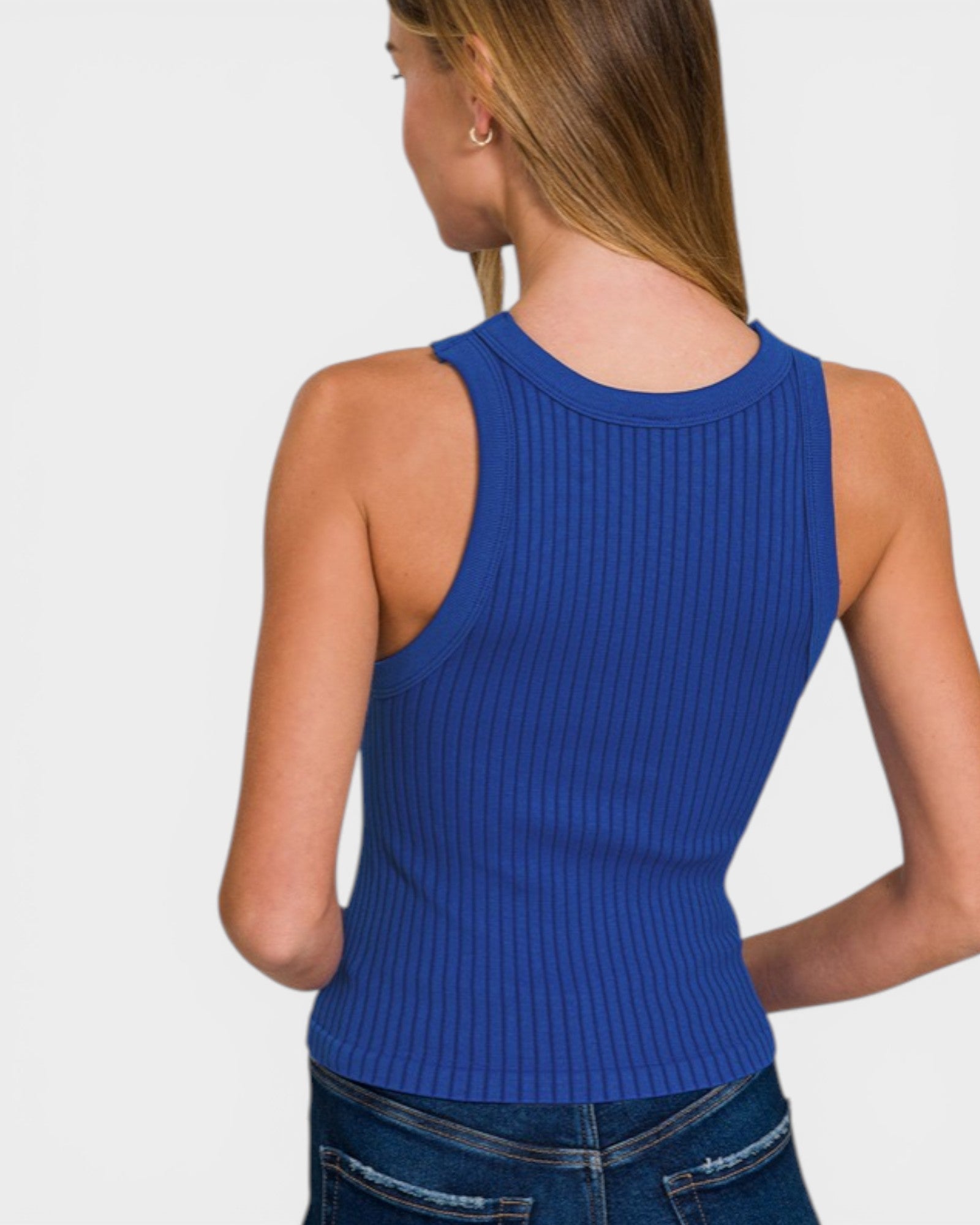 Person wearing a blue ribbed tank top on a plain background