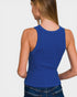 Person wearing a blue ribbed tank top on a plain background