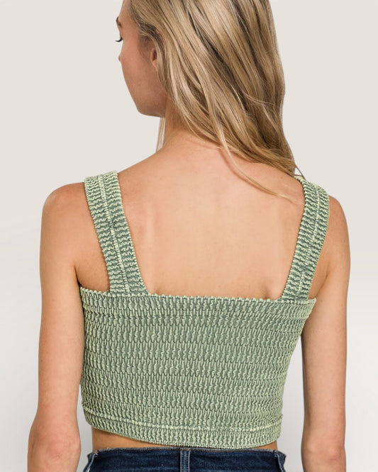 Green crochet top worn by a person on a plain background