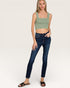 Woman wearing a green crop top and blue jeans on a white background