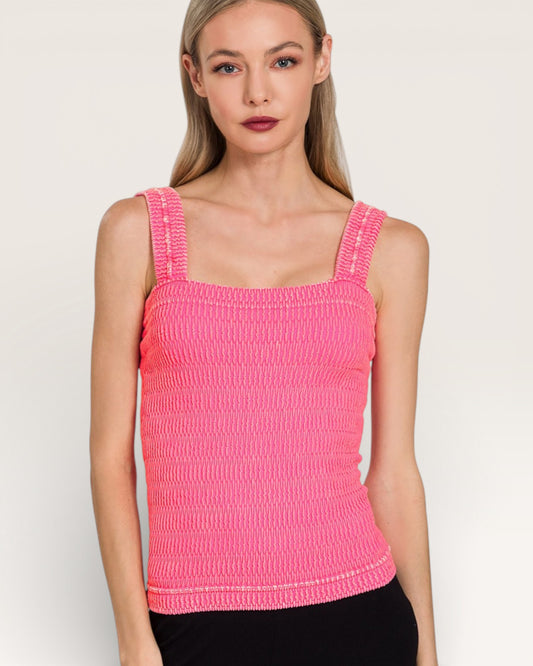 Woman wearing a pink textured tank top against a plain background
