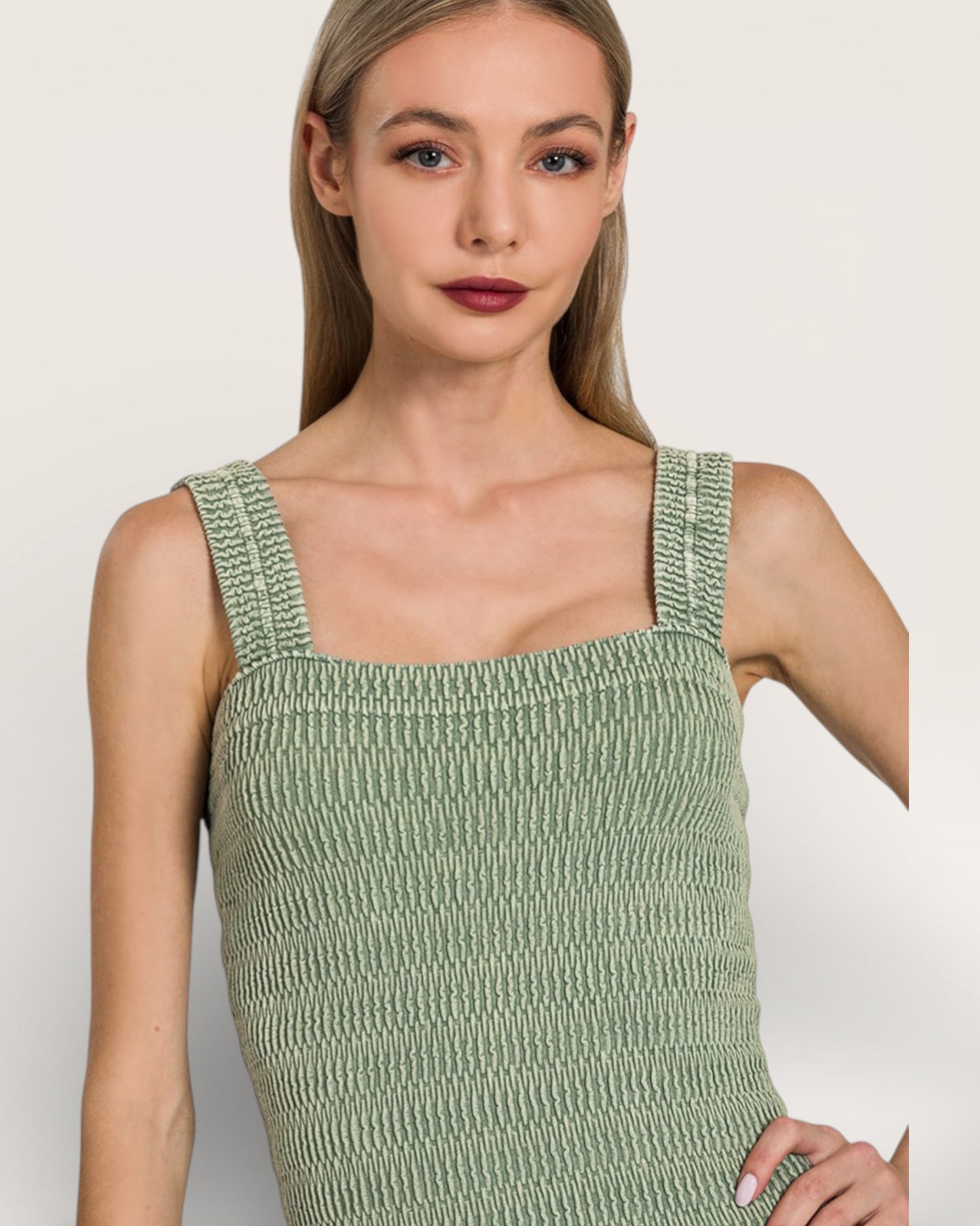 Woman wearing a green textured dress against a plain background