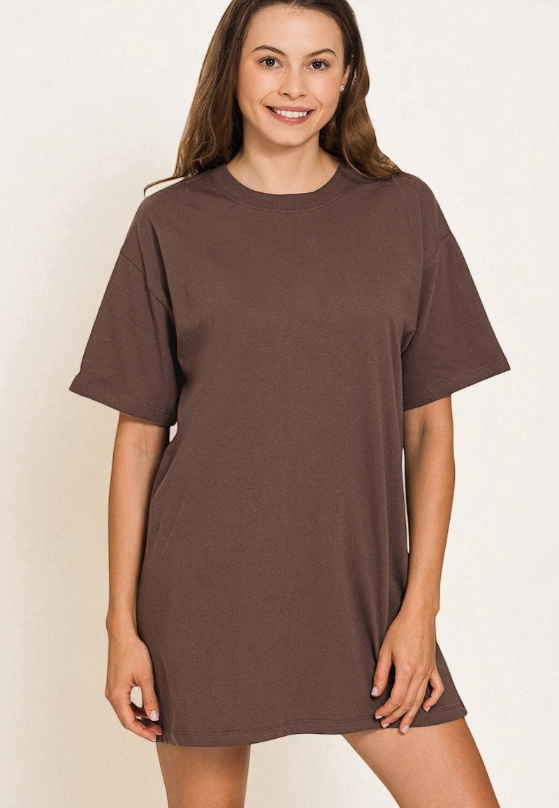 Woman wearing a brown t-shirt dress against a plain background