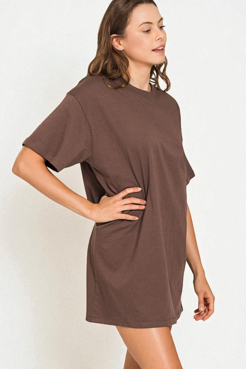 Woman wearing a brown t-shirt dress against a white background