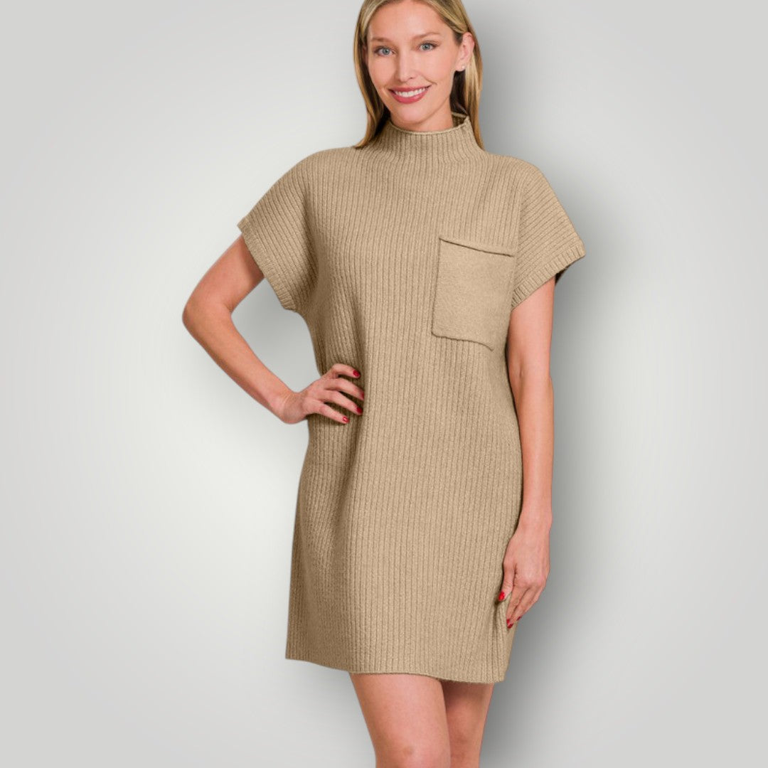 Woman wearing a beige dress with a pocket on a plain background