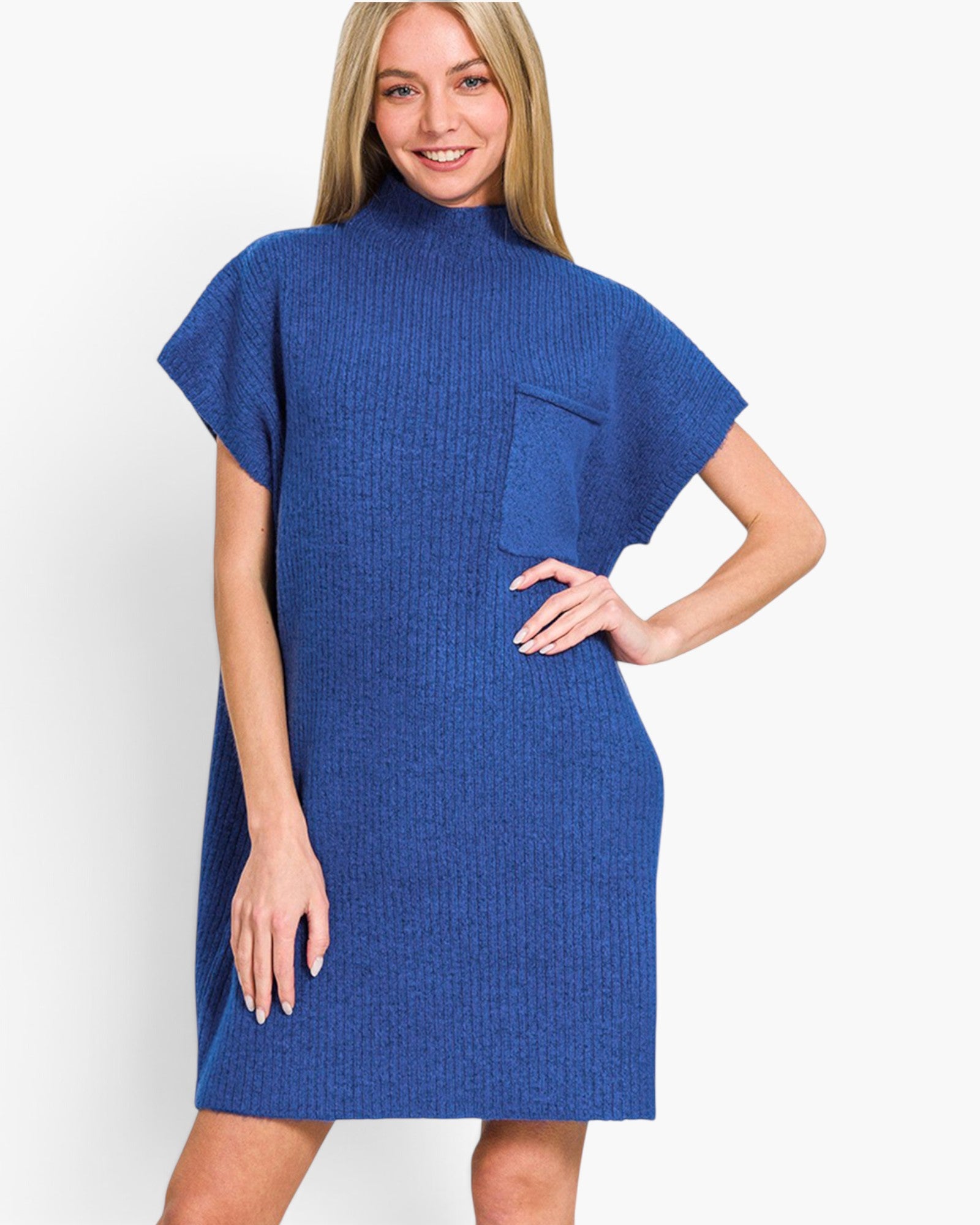 A woman modeling a blue ribbed knit mock-neck dress with short cape sleeves and a chest pocket, photographed against a clean white studio background.