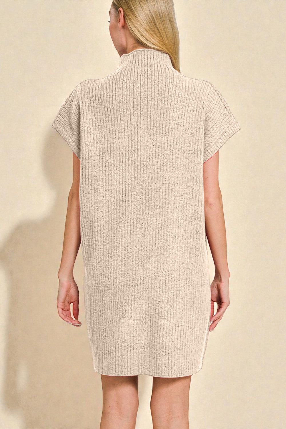 Woman wearing a beige textured dress against a beige background