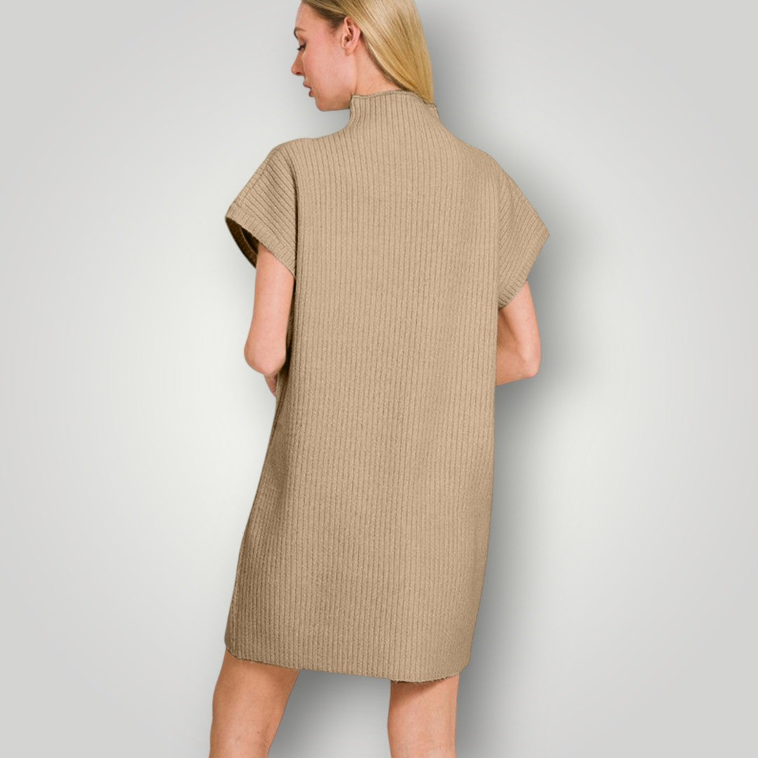 Woman wearing a beige ribbed dress against a plain background