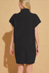 Person wearing a black dress against a beige background