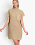 A woman modeling a beige ribbed knit mock-neck mini dress with short sleeves and a chest pocket, set against a plain light gray studio background.