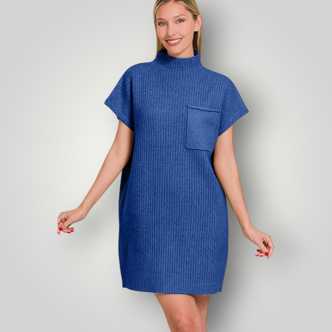 Woman wearing a blue dress with a pocket on a plain background