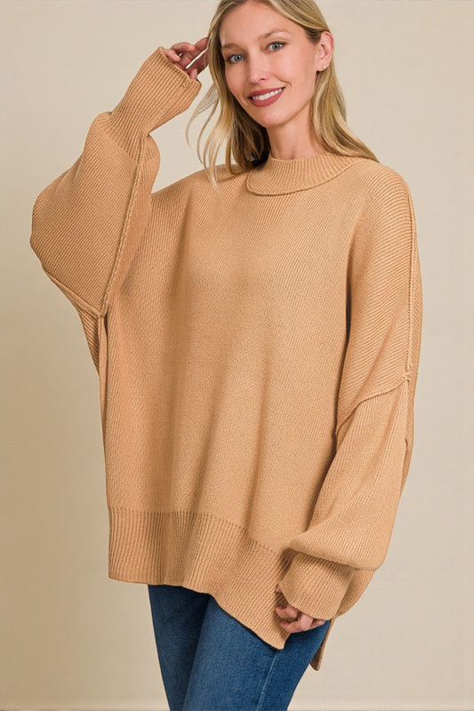 Woman wearing a beige sweater with a plain background