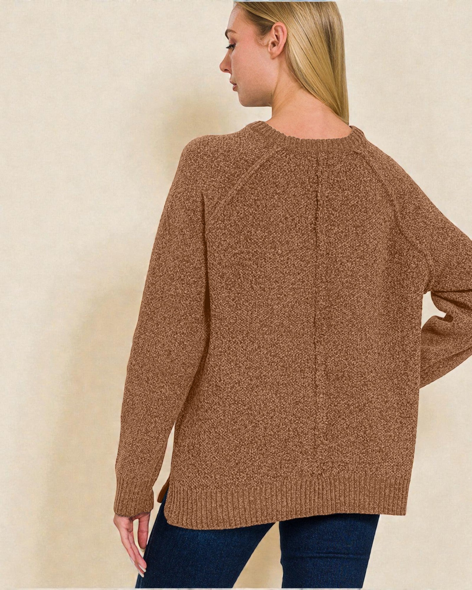 Woman wearing a brown sweater against a beige background