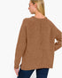 A woman shown from the back wearing a textured brown knit sweater and dark blue jeans against a plain white background.